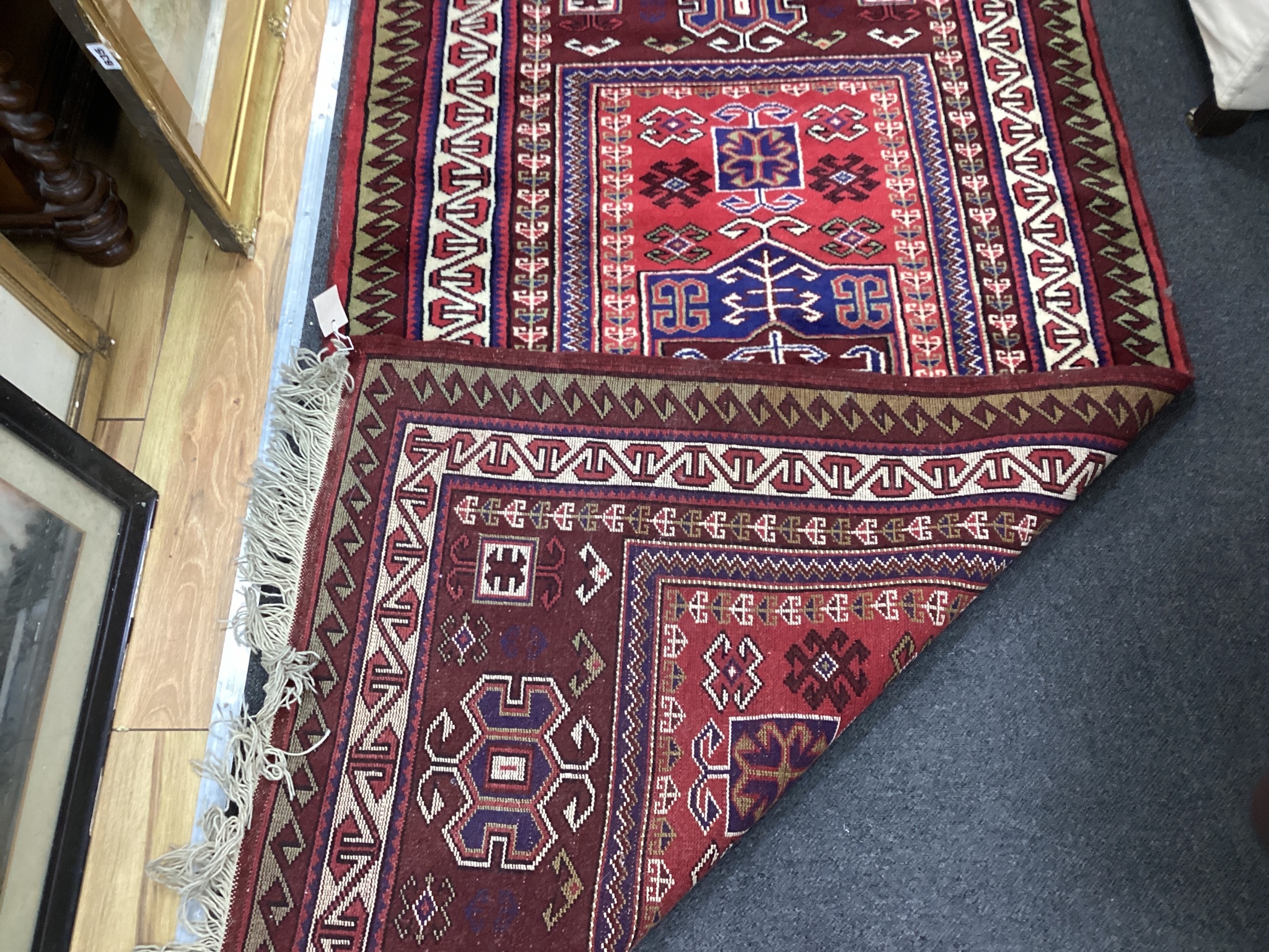 A Caucasian style red ground rug, 190 x 102cm